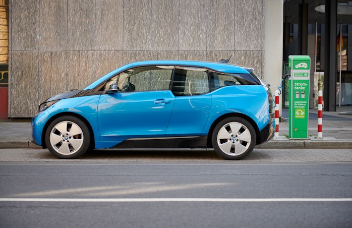 A BMW i3 parked next to a charger.