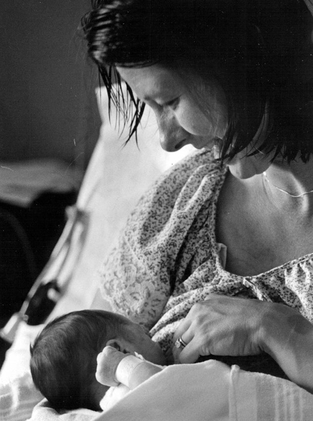 black and white photo of woman breastfeeding baby at hospital