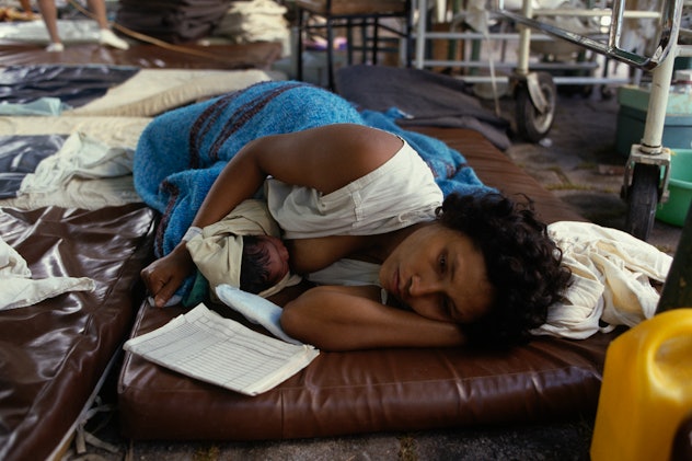 1980s photo of woman breastfeeding baby after earthquake in Ecuador