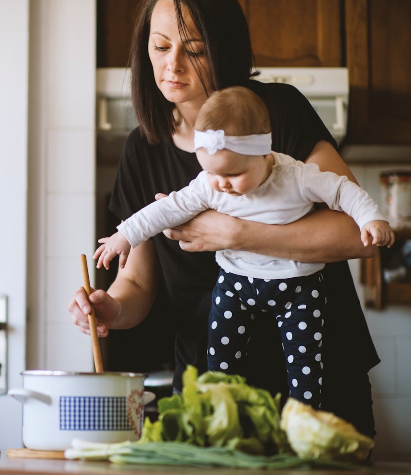 A mom holding her baby, making easy recipes for breastfeeding moms that are simple and healthy.