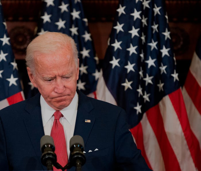 Former vice president Joe Biden can be seen looking down while standing at the podium. Behind Biden,...