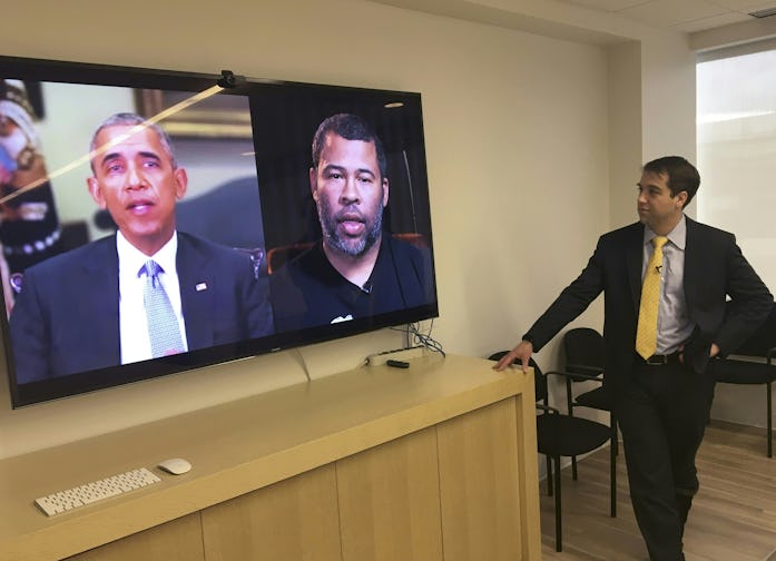 The former United States president Barack Obama is seen on a screen next to another screen showing c...