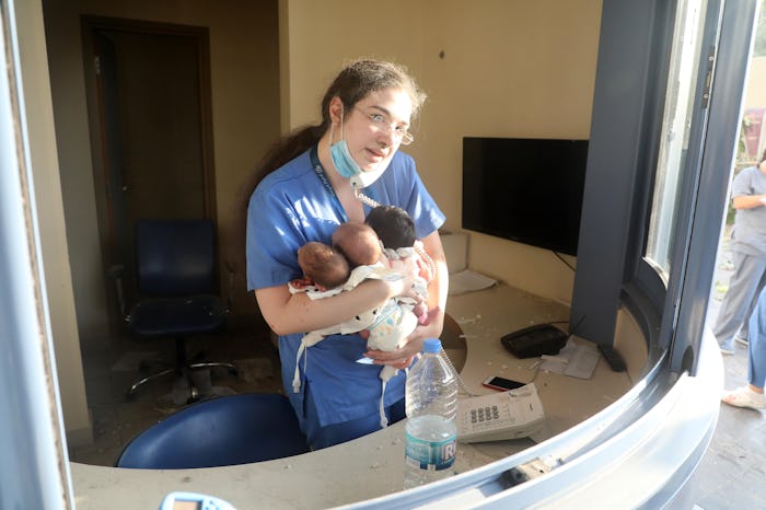 A photograph of a nurse in Lebanon holding three newborn babies hours after an explosion devastated ...
