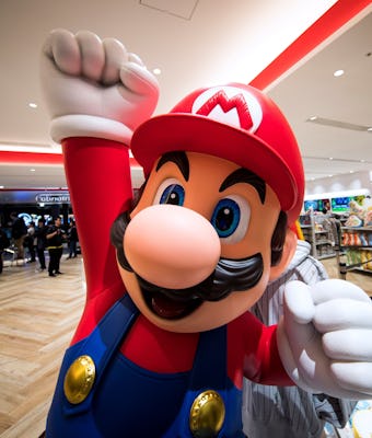 A large Mario statue can be seen with the Super Mario Brothers character throwing a fist in the air....