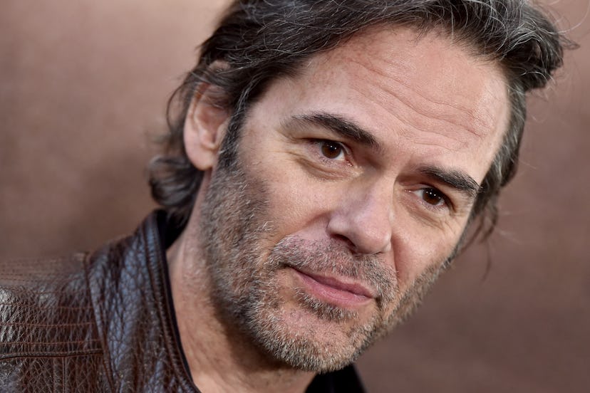 A close-up of Billy Burke's face. He wears a brown leather jacket.