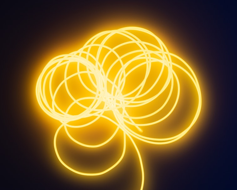A fluorescent wire can be seen in bright yellow color. It's made up of multiple spirals with its tai...