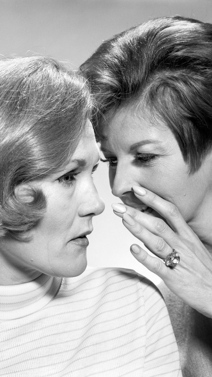 A woman tells her friend a secret. Researchers told the Atlantic that talking quietly could lower co...