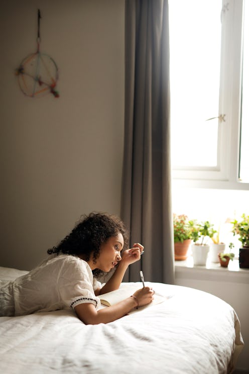 A woman lies on a couch with her head covered. The flu can impact mental health in surprising ways, ...