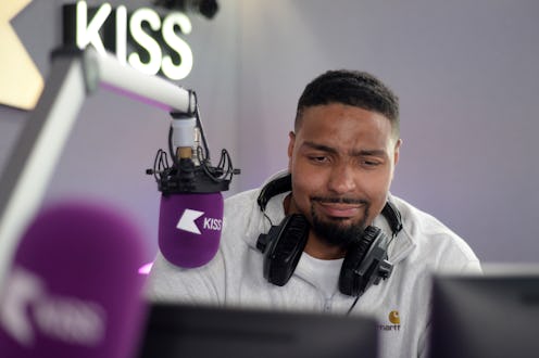 Jordan banjo pictured in the Kiss radio studio with headphones around his neck and a hurt expression...