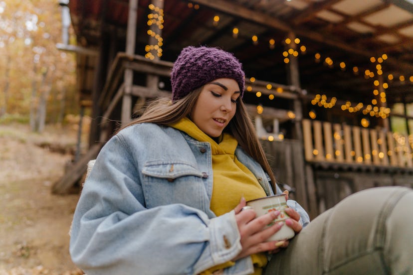 A woman in a purple beanie sits outside. You might start feeling seasonal affective disorder symptom...