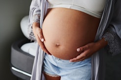 A pregnant woman who has used IVF, caressing her stomach