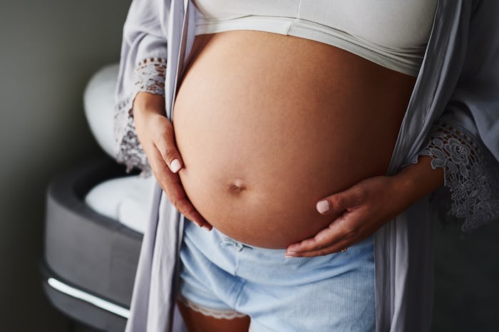 A pregnant woman who has used IVF, caressing her stomach