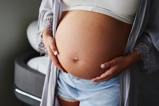 A pregnant woman who has used IVF, caressing her stomach