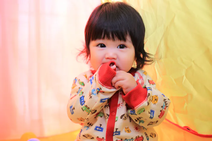 baby girl chewing on sleeves