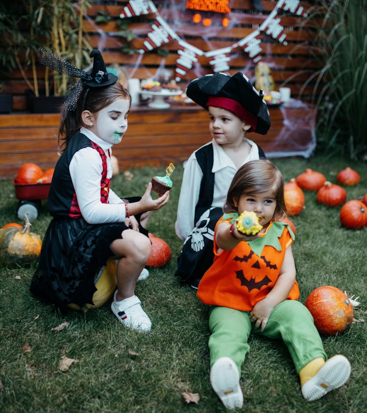 kids in halloween costumes sitting in backyard
