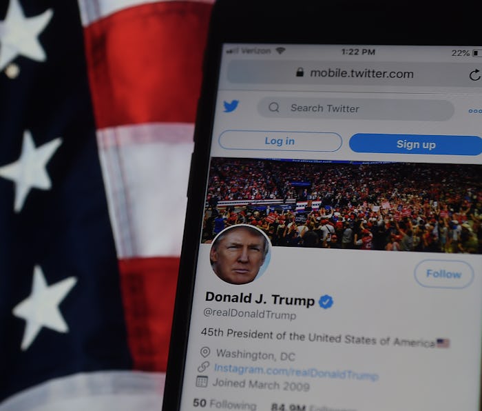 Trump's Twitter account displayed on an iPhone with a US flag in the background.