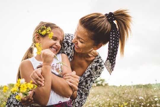 mom and daughter hugging in a field