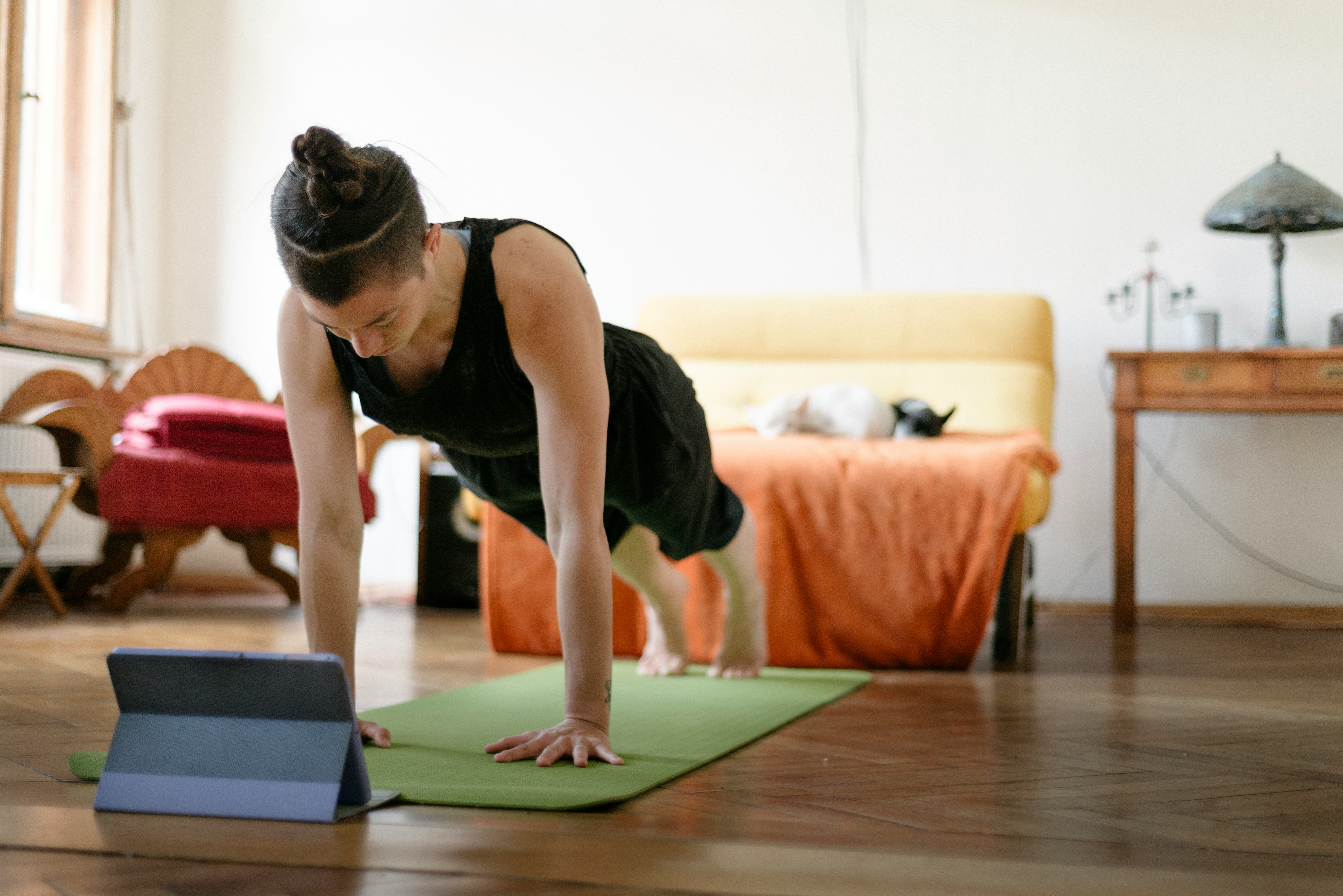 A woman works out watching a video on her iPad. Apple launched Fitness+, a new virtual streaming wor...