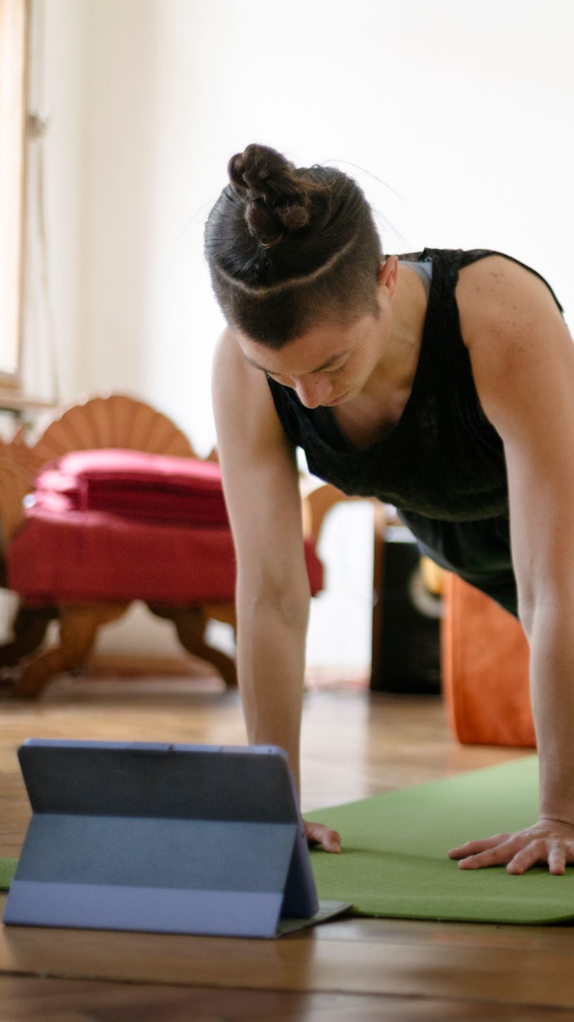 A woman works out watching a video on her iPad. Apple launched Fitness+, a new virtual streaming wor...