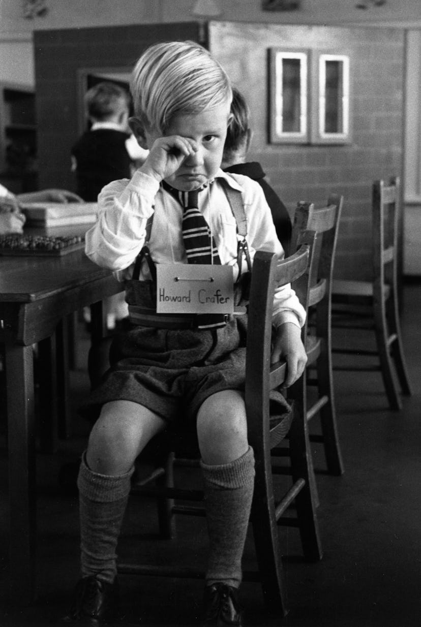 This vintage back to school photo shows a little boy upset on his first day of school. 
