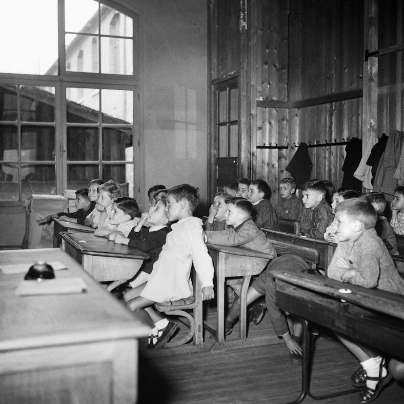 This vintage back to school photo shows a variety of students learning in their classroom. 
