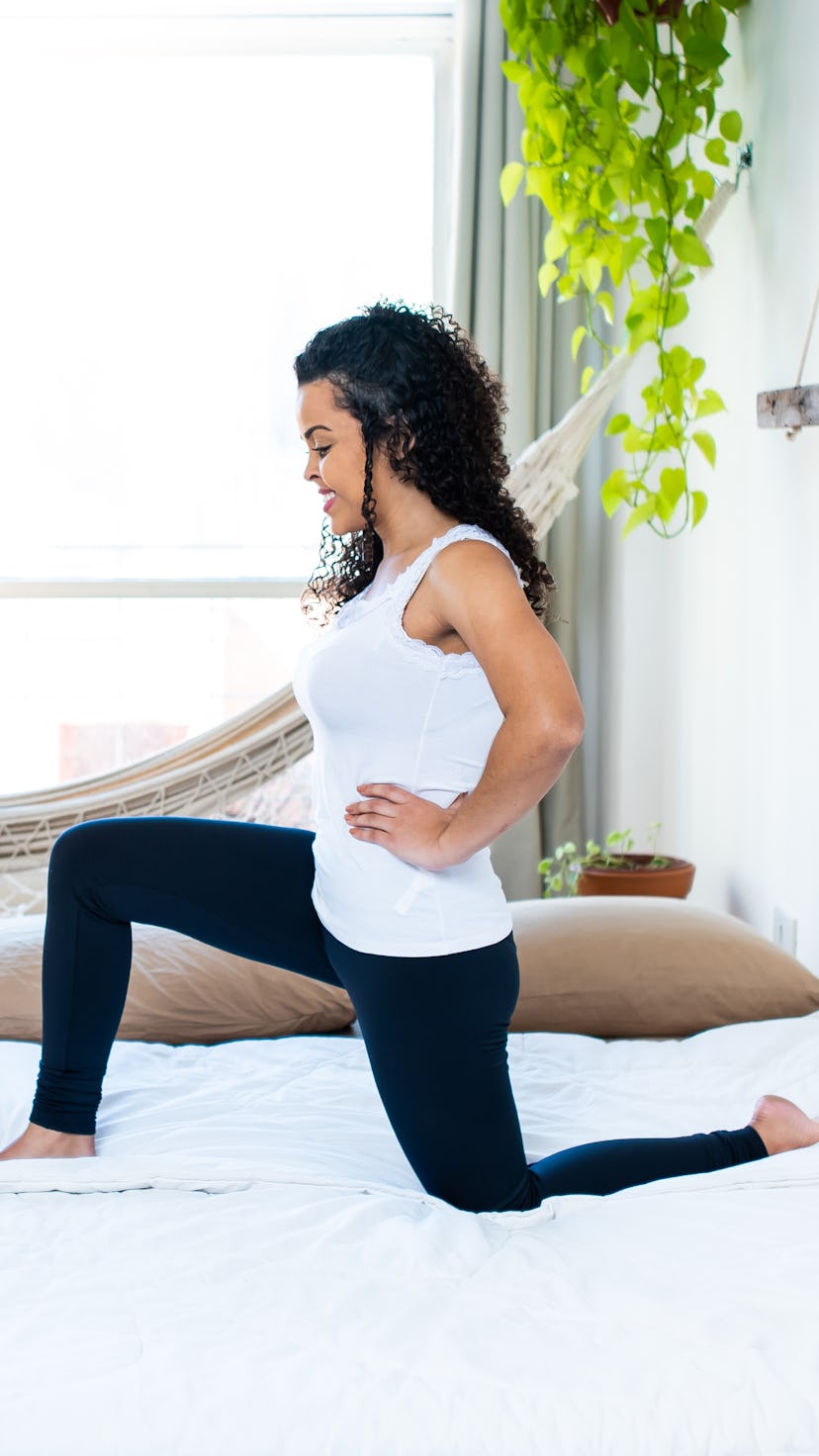 A person does lunges on their bed in a studio apartment. You don't need a big space to get a big wor...