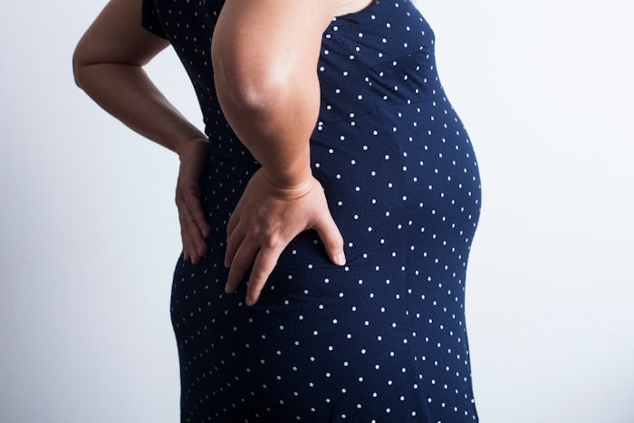 Pregnant woman with back pain because her boobs got bigger