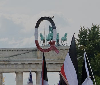 Symbol for the QAnon conspiracy movement is shown during a protest.
