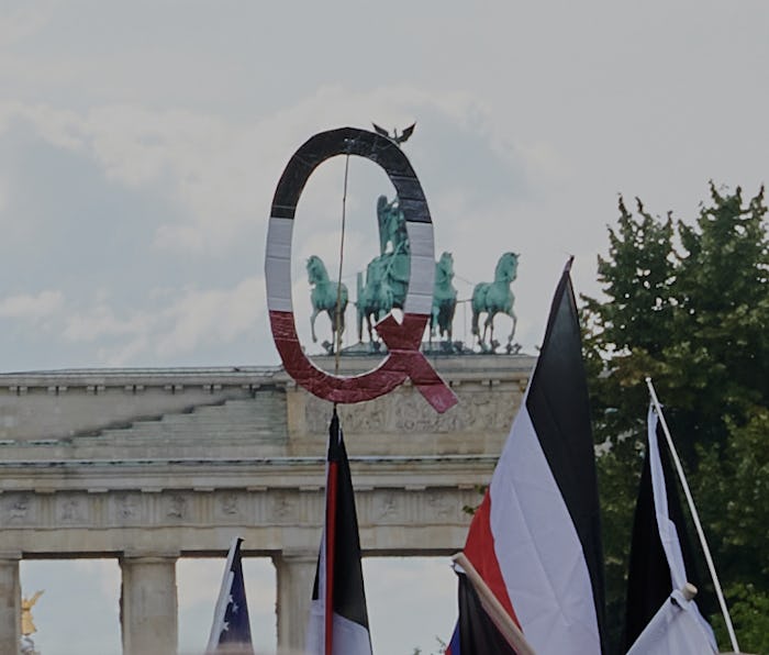 Symbol for the QAnon conspiracy movement is shown during a protest.