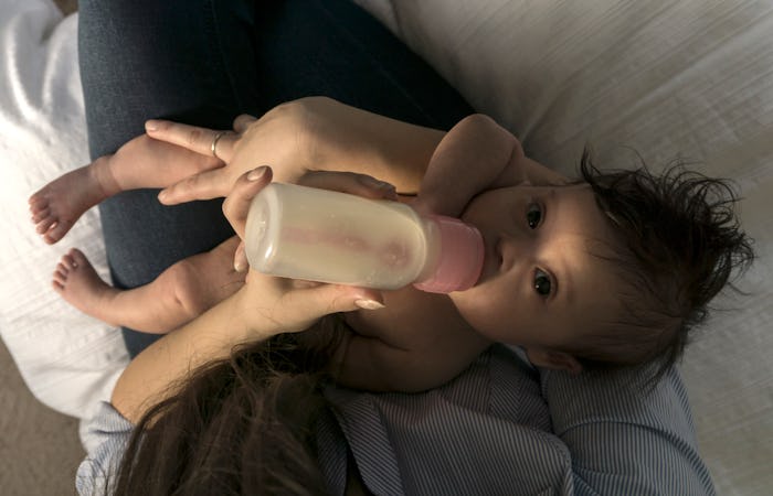 baby having a bottle on mom's lap
