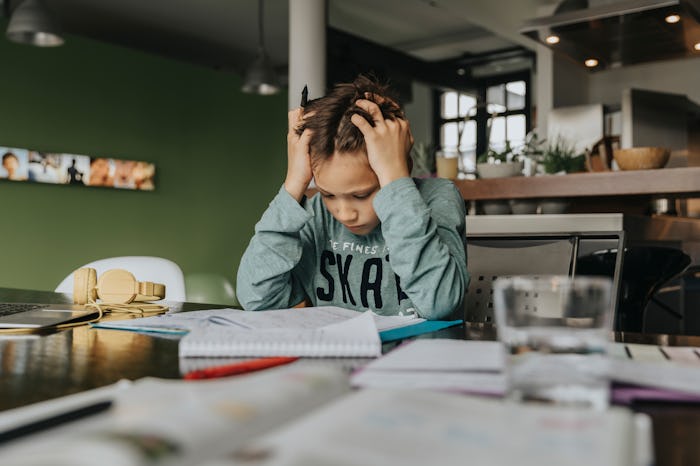 A kid with learning issues stressing out while doing homework at home