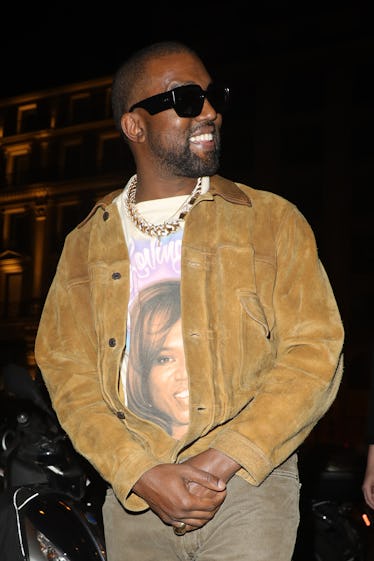 Kanye West steps out in a brown suede jacket and black shades.