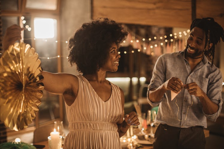A couple in nice clothes, decorates their backyard for a date night.