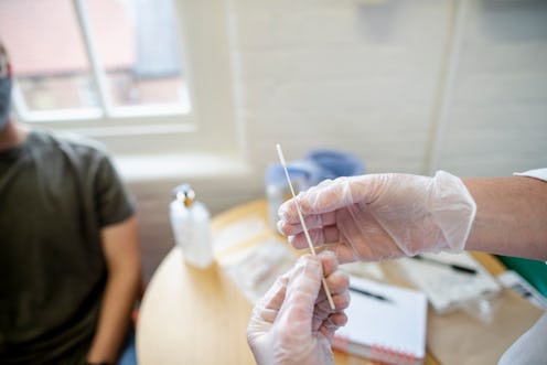A doctor holds a coronavirus testing swab. Reinfection with COVID-19 has been confirmed for the firs...