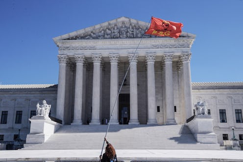 The Supreme Court, with a person flying a "Notorious RBG" flag. Law experts explain what could happe...