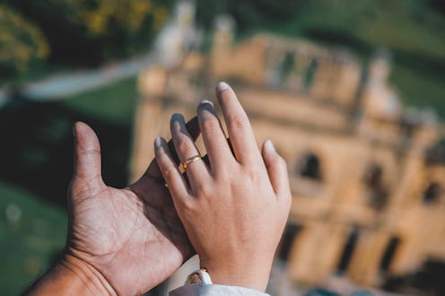 Two people hold hands on the roof of a building. Touch starvation is a real issue during the pandemi...