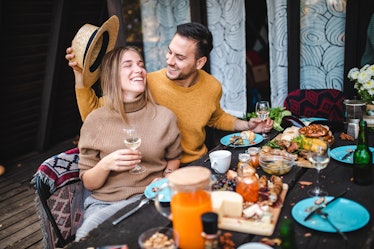 A happy couple enjoys a fall meal out on the porch. 