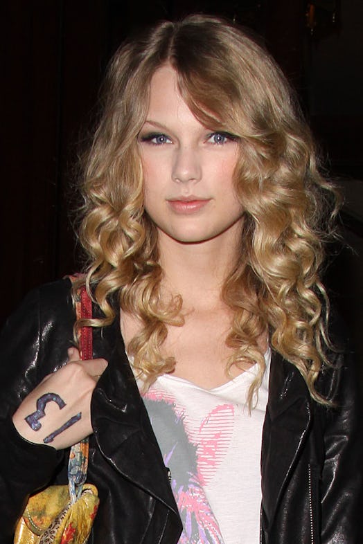 Taylor Swift steps out with the number '13' on her hand.