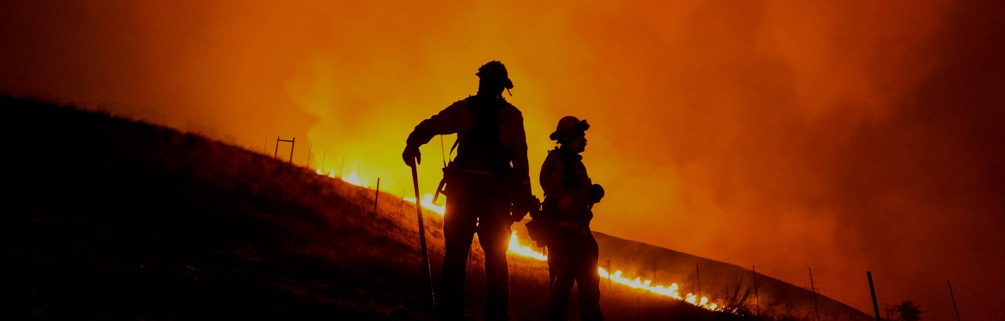 Two firefighters can be seen amid wildfires in California.