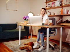 A young woman sits at a desk in her home office that she decorated all cozy for fall.