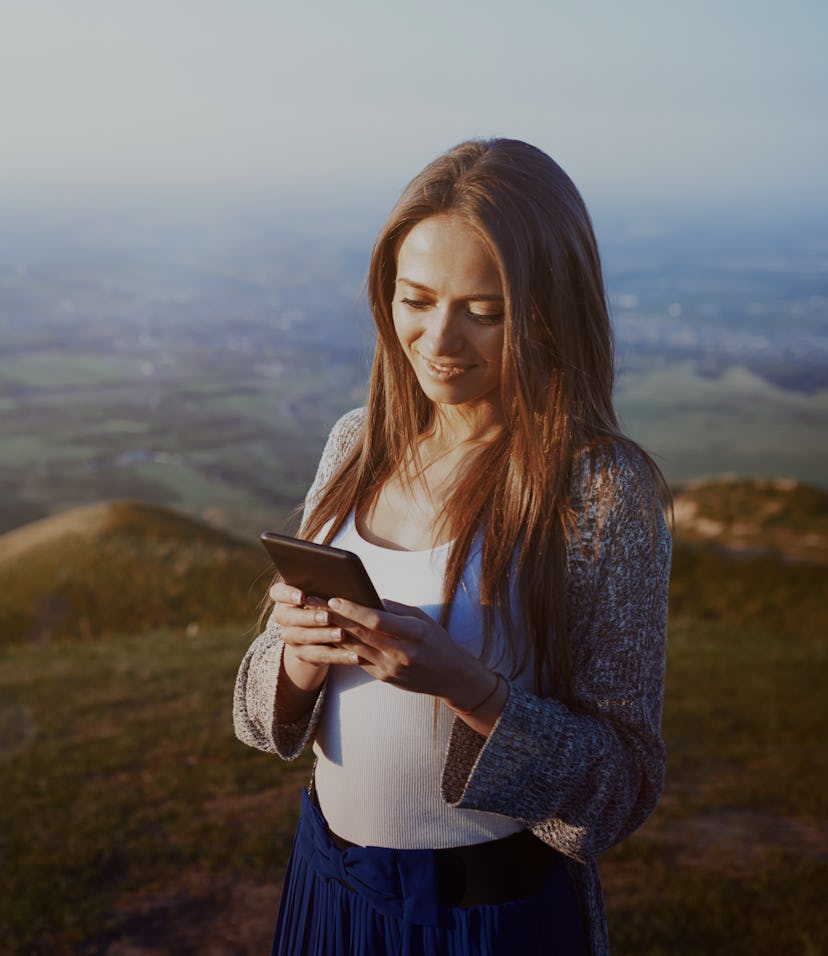 Woman looking at her phone out in nature.