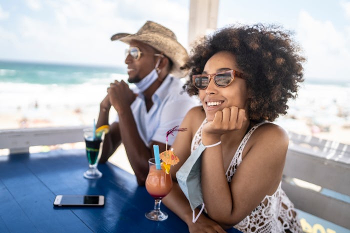woman drinking cocktail at beachside cafe