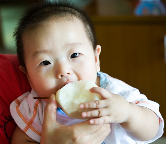 asian baby eating a pear