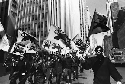 A group of protesters marching in an old black-white photograph and they're all wearing black