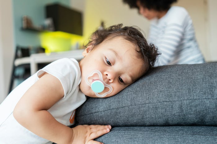 toddler resting head against couch cushions