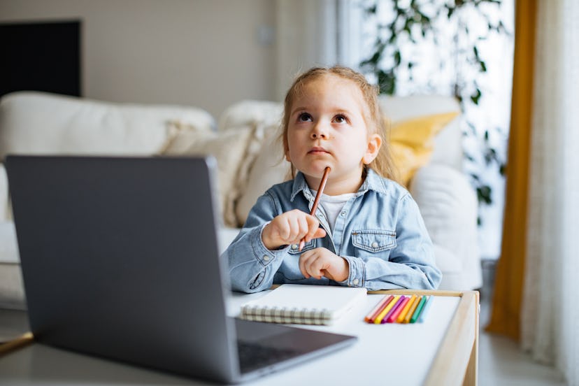 digital learning kindergarten student sitting with supplies in front of a computer 