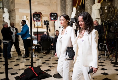 Two women activists walking and wearing matching white suits and white tops