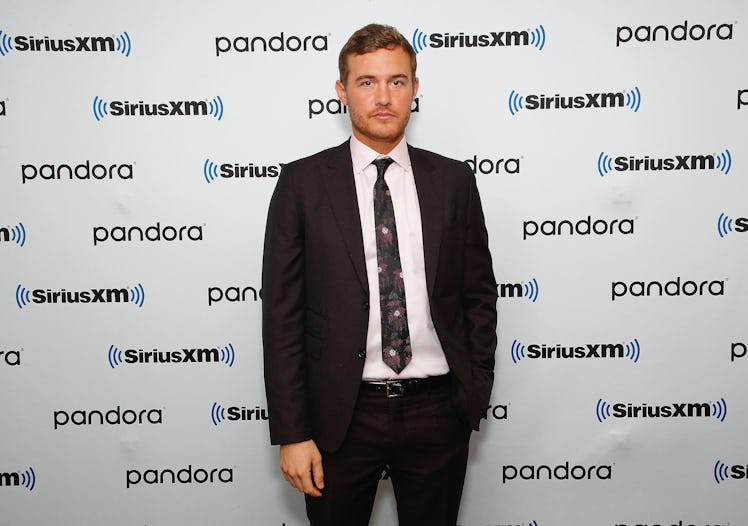 Peter Weber stands on the red carpet of an event in a suit and tie.