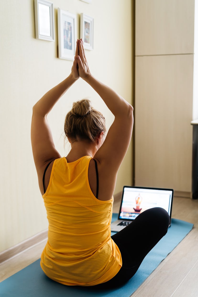 A woman does yoga at home as part of a fake commute.