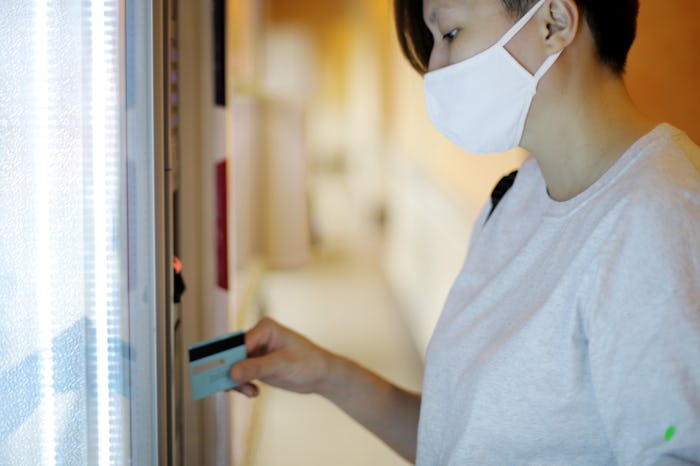 woman in face mask at vending machine